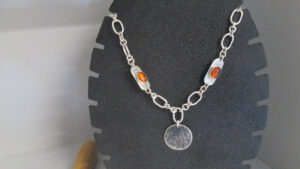 This is a silver link necklace with amber gemstones and a silver pendant, made on one of our Jewellery making courses at Brighton MET college.