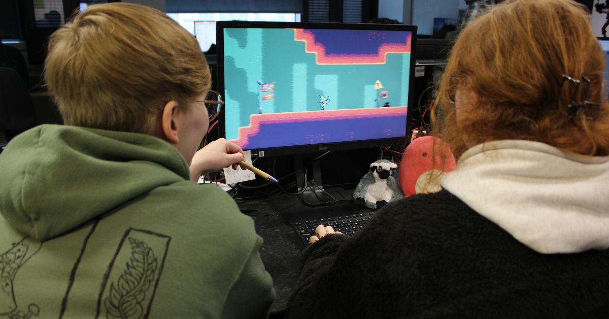 Students sat at PC working on their game